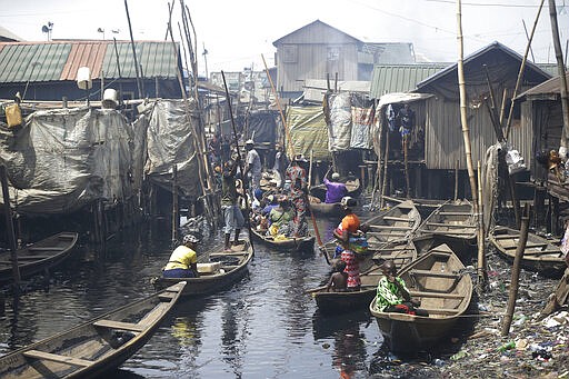 People travel by canoe in the floating slum of Makoko in Lagos, Nigeria, Saturday March 21, 2020. Lockdowns have begun in Africa as coronavirus cases rise above 1,000, while Nigeria on Saturday announced it is closing airports to all incoming international flights for one month in the continent's most populous country. Concerns are mounting for the welfare of Nigeria's most vulnerable community on stilts over spread of Covid-19 with little or no chances for social distancing as confirmed positive cases of the disease is on the rise. (AP Photo/Sunday Alamba)