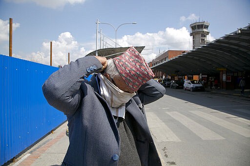 A Nepalese man covers his face with handkerchief at Tribhuvan International airpot in Kathmandu, Nepal, Monday, March 23, 2020. Nepalese government has suspended landing permission to all scheduled international airlines carrying Nepal inbound passengers as a precaution against COVID-19. For most people, the new coronavirus causes only mild or moderate symptoms. For some it can cause more severe illness. (AP Photo/Niranjan Shrestha)