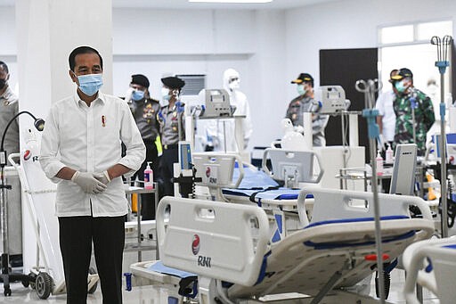 Indonesian President Joko Widodo, left, inspects medical equipments at an emergency hospital set up amid the new coronavirus outbreak in Jakarta, Indonesia, Monday, March 23, 2020. Indonesia has changed towers built to house athletes in the 2018 Asian Games to emergency hospitals with a 3,000-bed capacity in the country's hard-hit capital, where new patients have surged in the past week. (Hafidz Mubarak A/Pool Photo via AP)