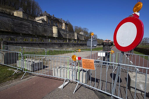 A man takes images with his mobile phone of the barricaded Netherlands-Belgium border between Maastricht, southern Netherlands, and Kanne, north-eastern Belgium, Monday, March 23, 2020. Roads between the two countries have been blocked for all non-essential travel. Both countries have come to a near standstill as the government sought to prevent the further spread of coronavirus. For most people, the new coronavirus causes only mild or moderate symptoms, such as fever and cough. For some, especially older adults and people with existing health problems, it can cause more severe illness, including pneumonia. (AP Photo/Peter Dejong)