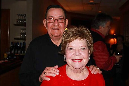 In this 2011 family photo provided by Dawn Bouska, Charles Recka and his wife, Patricia Recka, pose for a photo at a banquet in Naperville, Ill. Charles Recka died on March 12, 2020. Deep into the obituary for 87-year-old Recka is the short announcement that &quot;a Mass Celebrating his life will be held at a later date,&quot; a quiet signal popping up in death notices all over the country that the coronavirus that's changed everything about our lives has dramatically changed the way we grieve for the dead, too. (Courtesy of Dawn Bouska via AP)