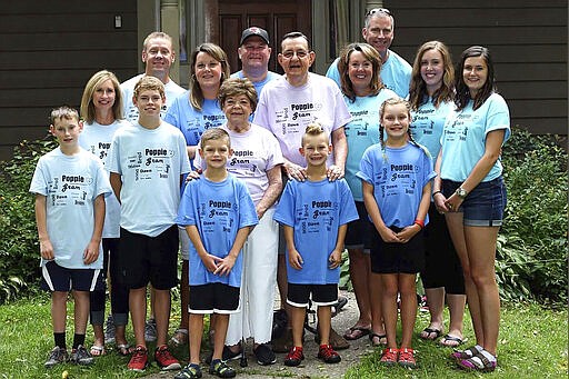 In this August 2016 family photo provided by Dawn Bouska, Charles and his wife, Patricia Recka, purplish shirts, are surrounded by their children and spouses, and grandchildren to celebrate their 60th wedding anniversary in Galena, Ill. Charles Recka died on March 12, 2020. Deep into the obituary for the 87-year-old is the short announcement that &quot;a Mass Celebrating his life will be held at a later date,&quot; a quiet signal popping up in death notices all over the country that the coronavirus that's changed everything about our lives has dramatically changed the way we grieve for the dead, too.  (Courtesy of Dawn Bouska via AP)