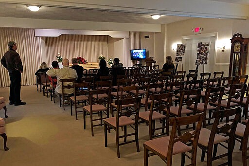 This March 18, 2020, photo shows a funeral that was affected by new rules put in place due to the coronavirus outbreak in Milwaukee. Wisconsin Gov. Tony Evers restricted gatherings to less than 10 people the day before. The coronavirus that's changed everything about our lives has dramatically changed the way we grieve for the dead, too. (AP Photo/Carrie Antlfinger)