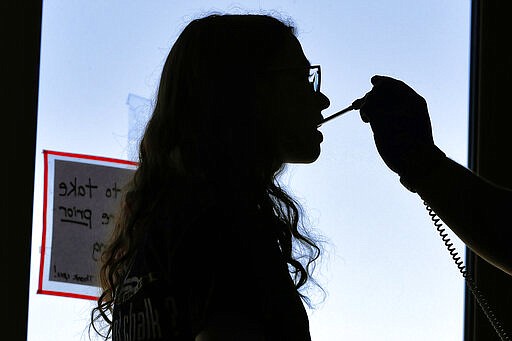 Emily Shippee has her temperature taken before being allowed to donate blood at a temporary blood bank set up in a church's fellowship hall Tuesday, March 24, 2020, in Tempe, Ariz. Schools and businesses that typically host blood drives are temporarily closed due to precautionary measures in place to reduce the spread of the COVID-19 coronavirus leading to extremely low levels of blood availability throughout the state. (AP Photo/Matt York)