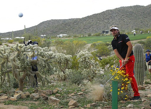 FILE - In this Feb. 23, 2014 file photo, Victor Dubuisson, of France, hits out of the desert on the 20th hole in his championship match against Jason Day, of Australia, during the Match Play Championship golf tournament in Marana, Ariz. Municipal leaders criticized Arizona Gov. Doug Ducey Tuesday, March 24, 2020 over his decision to classify some businesses like golf courses as &quot;essential&quot; during the coronavirus pandemic. Mayors of five different cities, including Tucson and Flagstaff, sent the Republican governor a letter Tuesday saying his executive order should not have included golf courses and payday lenders in the definition of &quot;essential services&quot; that cannot be shut down. (AP Photo/Ted S. Warren, File)