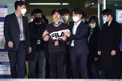 Cho Ju-bin, center, leader of South Korea's online sexual blackmail ring which is so called &quot;Nth room,&quot; walks out of a police station as he is transferred to prosecutors' office for further investigation in Seoul, South Korea, Wednesday, March 25, 2020. South Korean prosecutors on Wednesday began reviewing whether to formally charge a man arrested last week on allegations he operated secretive chatrooms where he posted sexually abusive videos of blackmailed women in return for cryptocurrency payments. (Kim Hong-Ji/Pool Photo via AP)