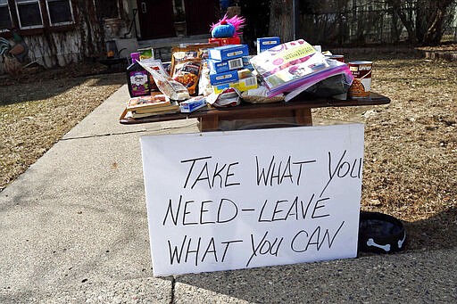 Food for the taking and an invitation to leave food is in front of a south Minneapolis home Monday, March 23, 2020 as Minnesotans care for others during the effort to slow down the coronavirus in the state. (AP Photo/Jim Mone)