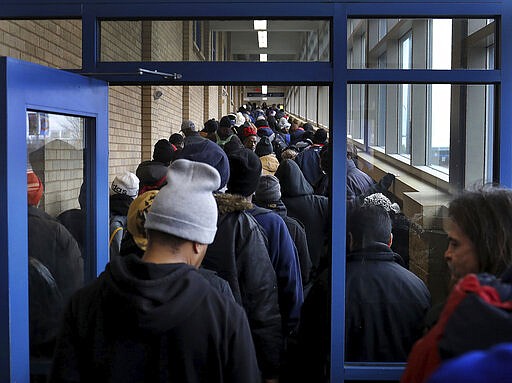 For some social distancing works, for the poor and homeless, getting food to eat doesn't always allow that as evidenced by the line for lunch at Sharing &amp; Caring Hands Tuesday, March 24, 2020, in Minneapolis. People in the line complained of a lack of safe places to go during the day with places like public libraries now closed and also said the lines for services for the homeless appears to be quickly growing. (David Joles/Star Tribune via AP)