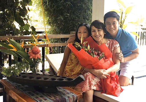 In this August 2019, photo, Carlo Navarro poses with his wife Evie and daughter Gia for a family photo in Lipa, Philippines. When Carlo Navarro, his wife and their 15-year-old daughter visited Japan from the Philippines in February 2020, they knew they were taking a chance with the coronavirus, but thought they would be spared if they took precautions. They wore masks and gloves and always had alcohol handy to sanitize their hands. But the 48-year-old tax lawyer, began showing symptoms after they returned home. Days after he was cleared and discharged from hospital, Navarro shared his COVID-19 experience on a Facebook public post. (Carlo Navarro via AP)