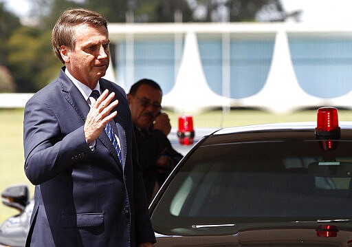 Brazil's President Jair Bolsonaro waves as he leaves the presidential residence Alvorada Palace, after learning that he tested negative for the new coronavirus, in Brasilia, Brazil, Friday, March 13, 2020. Concern about Bolsonaro&#146;s exposure to the coronavirus &#151; and possibly that of U.S. President Donald Trump &#151; had grown after confirmation that the Brazilian leader&#146;s communications director tested positive. The senior official had joined Bolsonaro just days earlier at a meeting with Trump and senior aides in Florida. (AP Photo/Beto Barata)