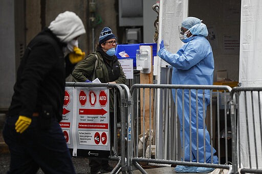 A medical worker speaks with patients at a COVID-19 testing station at The Brooklyn Hospital Center, Monday, March 23, 2020, in New York. (AP Photo/John Minchillo)