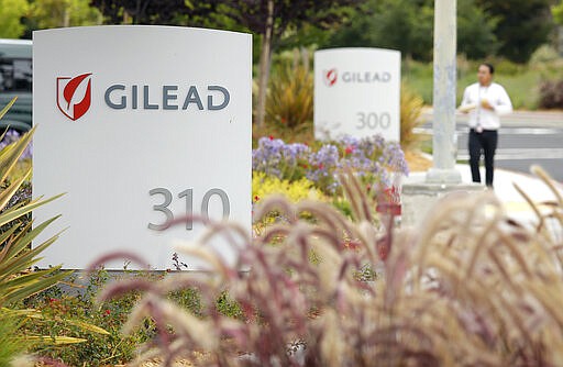 FILE - In this July 9, 2015, file photo, a man walks outside the headquarters of Gilead Sciences in Foster City, Calif. Gilead, the&#160;pharmaceutical giant that makes remdesivir,&#160;a promising coronavirus drug, has registered it as a rare disease treatment with U.S. regulators on Monday, March 23, 2020, a status that can potentially be worth millions in tax breaks and competition-free sales. (AP Photo/Eric Risberg, File)