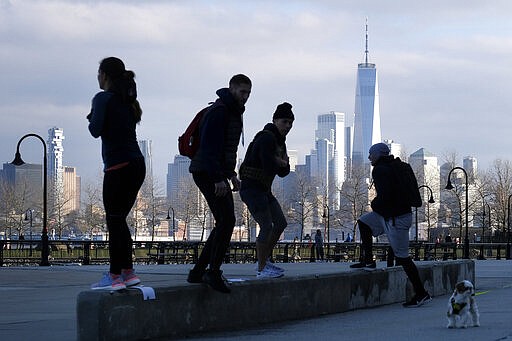 People exercise outdoors with a view of Manhattan in Hoboken, N.J., March 17, 2020. (AP Photo/Seth Wenig)