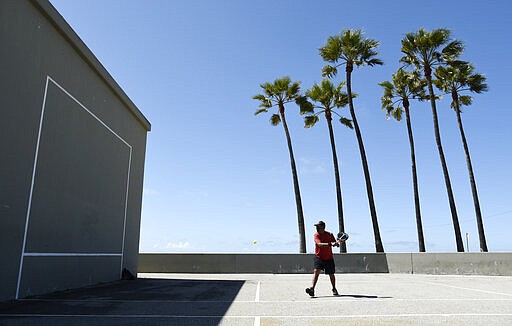 Lemmon McMillan of Playa del Rey, Calif., plays racquetball on the Venice Beach Boardwalk, March 23, 2020, in Los Angeles. (AP Photo/Chris Pizzello)