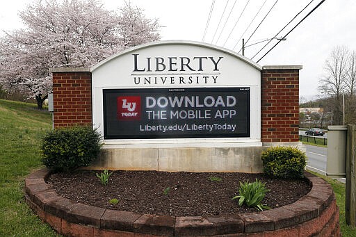 A sign marks the entrance to Liberty University, Tuesday March 24 , 2020, in Lynchburg, Va. Officials in Lynchburg said Tuesday they were fielding complaints and concerns about the hundreds of students that have returned from their spring break to Liberty University, where President Jerry Falwell Jr. has welcomed them back amid the coronavirus pandemic. (AP Photo/Steve Helber)