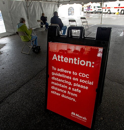 Seated in chairs set eight feet apart, blood donors wait to be taken to one of three mobile blood centers during a blood drive Monday, March 23, 2020 hosted by Marsh Regional Blood Center at the Bristol Motor Speedway in Bristol, Tenn. With a nationwide shortage of blood supply growing, the blood drive provides local residents the opportunity to donate in a time of need due to the Coronavirus pandemic. (David Crigger/Bristol Herald Courier via AP)