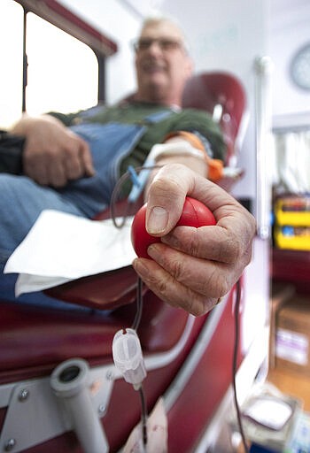 Eddie Davidson donates blood Monday, March 23, 2020 during a daylong blood drive held by Marsh Regional Blood Center at Bristol Motor Speedway in Bristol, Tenn. With a nationwide shortage of blood supply growing, the blood drive provides local residents the opportunity to donate in a time of need due to the coronavirus pandemic. (David Crigger/Bristol Herald Courier via AP)