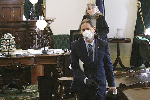 Vermont Lt. Gov. David Zuckerman wears a mask in the Vermont Senate chamber, Tuesday March 24, 2020, at the Statehouse in Montpelier, Vt. The Senate met with 17 members, one over the required quorum, to pass legislation needed to confront the coronavirus pandemic. (Paul Heintz/Seven Days, Pool via AP)