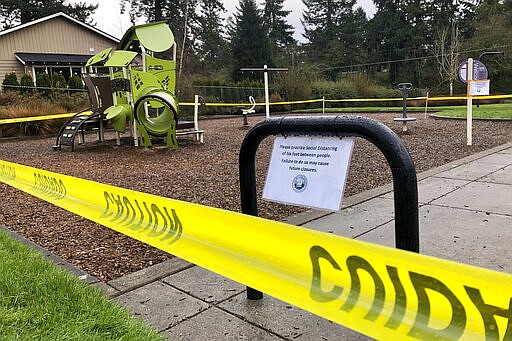 Police caution tape surrounds a playground in Lake Oswego, Ore., on Tuesday, March 24, 2020, the day after Gov. Kate Brown issued a statewide stay-at-home order that closed many businesses, as well as all playgrounds, sport courts, and skating rinks. Brown issued the executive order Monday after crowds of people swarmed the state's beaches, hiking trails and parks over the weekend. (AP Photo/Gillian Flaccus)