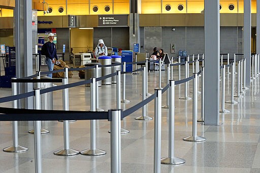 A check-in area at the Raleigh Durham International Airport is mostly void of travelers in Raleigh, N.C., Tuesday, March 24, 2020. The coronavirus has impacted travel throughout much of the world as flights have been canceled or delayed. (AP Photo/Gerry Broome)