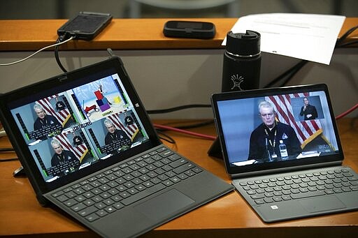 Laptops are used to monitor the live stream of a press briefing by Mike Sprayberry, North Carolina Director of Emergency Management and Dr. Elizabeth Cuervo Tilson, North Carolina State Health Director, Chief Medical Officer on the COVID-19 and coronavirus on Tuesday, March 24, 2020 at the Emergency Operations Center in Raleigh, N.C.  (Robert Willett/The News &amp; Observer via AP)