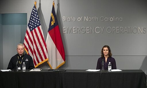 Mike Sprayberry, North Carolina Director of Emergency Management, and Dr. Elizabeth Cuervo Tilson, North Carolina State Health Director, Chief Medical Officer, keep the proper distance between them during a press briefing to update the public on the COVID-19 virus on Tuesday, March 24, 2020 at the Emergency Operations Center in Raleigh, N.C.  (Robert Willett/The News &amp; Observer via AP)