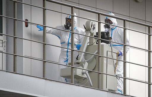 Medical workers move a medical device at the Botkin isolation hospital, where patients are kept in isolation for possible inflection by the new coronavirus, in St.Petersburg, Russia, Tuesday, March 24, 2020, with Russia only reporting a few hundred virus cases. The highly contagious COVID-19 coronavirus can cause mild symptoms, but for some it can cause severe illness including pneumonia. (AP Photo/Dmitri Lovetsky)