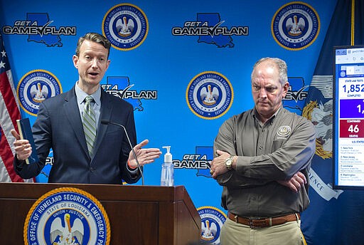 Louisiana Gov. John Bel Edwards, right, listens as Alex Billioux, M.D., left, Assistant Secretary of Health for the Louisiana Dept. of Health's Office of Public Health, answers a question at a briefing of media members on the state's coronavirus response at the Governor's Office of Homeland Security &amp; Emergency Management, Tuesday, March 24, 2020, in Baton Rouge, La. (Travis Spradling/The Advocate via AP, Pool)