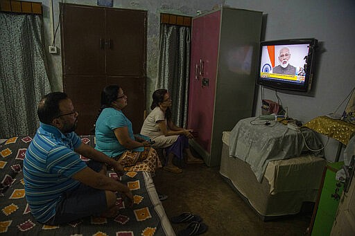 An Indian family watches Prime Minister Narendra Modi address the nation in a televised speech about COVID-19 situation, in Gauhati, India, Tuesday, March 24, 2020. Modi Tuesday announced a total lockdown of the country of 1.3 billion people to contain the new coronavirus outbreak. For most people, the new coronavirus causes only mild or moderate symptoms. For some it can cause more severe illness. (AP Photo/Anupam Nath)