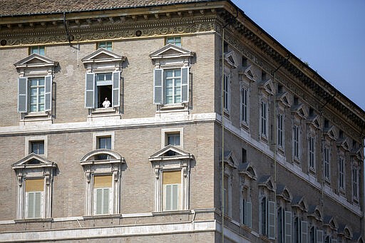 Pope Francis delivers his blessing from the window of his private library overlooking an empty St. Peter's Square, at the Vatican, Sunday, March 22, 2020. During his weekly Sunday blessing, held due to virus concerns in his private library in the Apostolic Palace, he urged all Christians to join in reciting the ''Our Father'' prayer next Wednesday at noon. For most people, the new coronavirus causes only mild or moderate symptoms. For some it can cause more severe illness, especially in older adults and people with existing health problems. (AP Photo/Alessandra Tarantino)