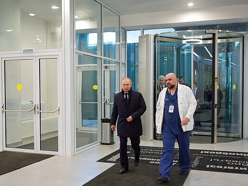 Russian President Vladimir Putin, left, and the hospital's chief Denis Protsenko enter the hall of the hospital for coronavirus patients in Kommunarka settlement, outside Moscow, Russia, Tuesday, March 24, 2020. During a visit to the Komunarka hospital on Moscow outskirts, Putin praised its doctors for high professionalism, saying they were working &quot;like clockwork.&quot; (Alexei Druzhinin, Sputnik, Kremlin Pool Photo via AP)