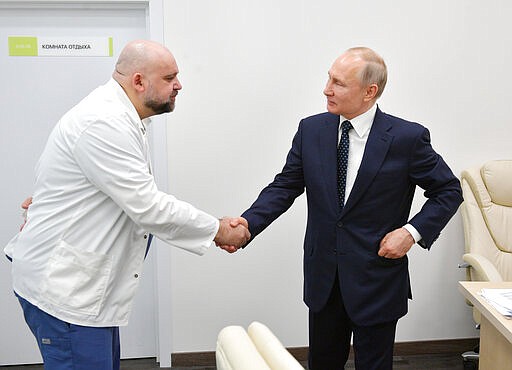 Russian President Vladimir Putin, right shakes hands with the hospital's chief Denis Protsenko during his visit to the hospital for coronavirus patients in Kommunarka settlement, outside Moscow, Russia, Tuesday, March 24, 2020. During a visit to the Komunarka hospital on Moscow outskirts, Putin praised its doctors for high professionalism, saying they were working &quot;like clockwork.&quot; (Alexei Druzhinin, Sputnik, Kremlin Pool Photo via AP)