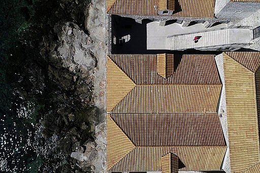 This Tuesday, March 17, 2020 aerial photo shows roofs and the atrium of the Lazarettos, called Lazareti in Croatian,  of Dubrovnik, in Dubrovnik, Croatia. Just outside the majestic walls of Croatia&#146;s medieval citadel city of Dubrovnik lies a cluster of small stone houses known as the Lazzarettos of Dubrovnik, today an art and clubbing hub and a tourist attraction. But the coronavirus spreads worldwide, some are recalling their original purpose centuries ago as an isolation zone for arrivals who might be carrying infectious diseases. Dubrovnik, on the Adriatic coast, was the first city in Europe to set up a quarantine system, in 1377, as protection from leprosy. The Lazzarettos complex was built in the 17th century when authorities decided to set up the quarantine area closer to the harbor. (AP Photo/Darko Bandic)