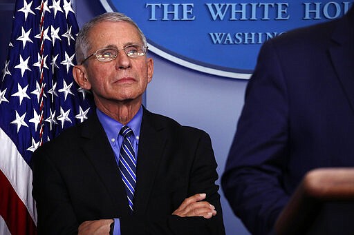 Dr. Anthony Fauci, director of the National Institute of Allergy and Infectious Diseases, listens as President Donald Trump speaks about the coronavirus in the James Brady Briefing Room, Tuesday, March 24, 2020, in Washington. (AP Photo/Alex Brandon)