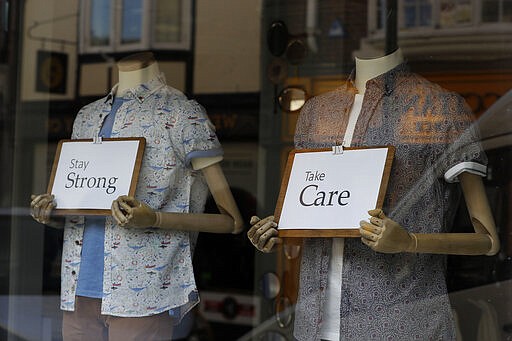 Messages of support are seen in a shop window in Windsor, England Tuesday, March 24, 2020. Britain's Prime Minister Boris Johnson on Monday imposed its most draconian peacetime restrictions due to the spread of the coronavirus on businesses and gatherings.  For most people, the new coronavirus causes only mild or moderate symptoms. For some it can cause more severe illness.(AP Photo/Kirsty Wigglesworth)