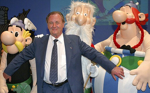 FILE - In this June 12, 2004 file photo, French illustrator Albert Uderzo poses with characters of his famous comics, Asterix, left, druid Miraculix, behind, and Obelix , right, during the awarding of the so called &quot;Max &amp; Moritz&quot; award by the Erlangen Comic Salon2004 in Erlangen, southern Germany. Albert Underzo, one of the two creators of the beloved comic book character Asterix, who captured the spirit of the Gauls of yore and grew a reputation worldwide, died early Tuesday March 24, 2020. He was 92. (AP Photo/Frank Boxler, File)