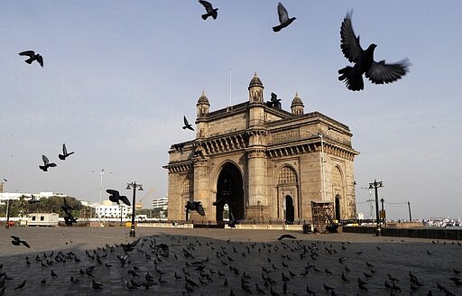 Pigeons fly at a deserted Gateway of India monument in Mumbai, India, Tuesday, March 24, 2020. Indian Prime Minister Narendra Modi has decreed a 21-day lockdown across the nation of 1.3 billion people &#147;to save India&#148; from the coronavirus pandemic.  For most people, the new coronavirus causes only mild or moderate symptoms. For some it can cause more severe illness.(AP Photo/Rajanish Kakade)