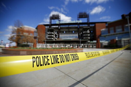 Police tape blocks an entrance to Citizens Bank Park, home of the Philadelphia Phillies baseball team, Tuesday, March 24, 2020, in Philadelphia. The park is a temporary testing site for COVID-19,  the disease caused by the new coronavirus. For most people, the virus causes only mild or moderate symptoms. For some it can cause more severe illness. (AP Photo/Matt Slocum)