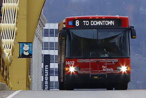 A Pittsburgh Port Authority bus crosses the Andy Warhol bridge in Downtown Pittsburgh Tuesday, March 24, 2020. With ridership down more than 50% due to the COVID-19 emergency the Port Authority is cutting service by 25% beginning Wednesday. (AP Photo/Gene J. Puskar)