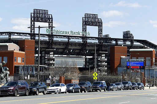 Cars line up outside a COVID-19 testing site near Citizens Bank Park, home of the Philadelphia Phillies baseball team, Tuesday, March 24, 2020, in Philadelphia. (AP Photo/Matt Slocum)