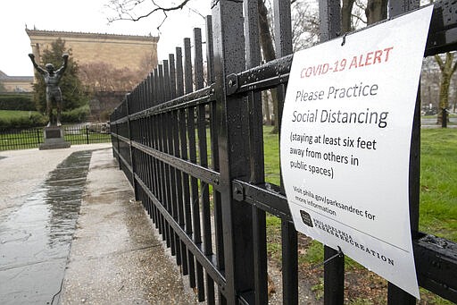 A COVID-19 advisory, the disease caused by the new coronavirus, is posted by the the Rocky statue at the Philadelphia Museum of Art in Philadelphia, Monday, March 23, 2020. (AP Photo/Matt Rourke)