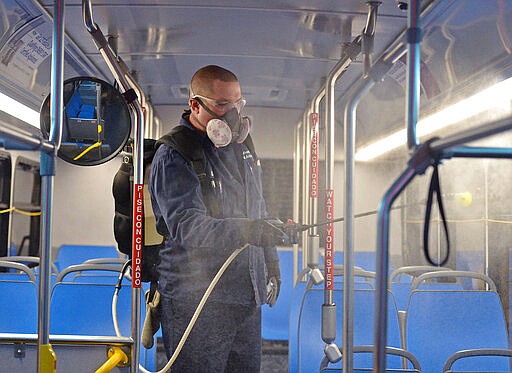 Greg Pietras, 51, a utility worker at the Erie Metropolitan Transit Authority, demonstrates how the interior of buses are misted with a disinfectant as part of the bus cleaning process. Each day, the EMTA, based in Erie, Pennsylvania, cleans about 60 buses that are currently being used for daily service as the authority prepares for the spread of the coronavirus in the Erie, Pennsylvania region. (Christopher Millette/Erie Times-News via AP)