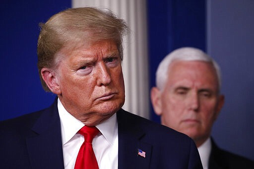 President Donald Trump and Vice President Mike Pence listen during a briefing about the coronavirus in the James Brady Briefing Room, Tuesday, March 24, 2020, in Washington. (AP Photo/Alex Brandon)