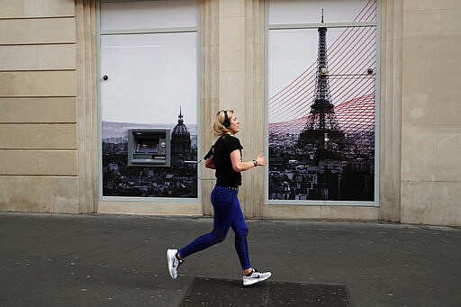 A woman jogs in Paris, March 22, 2020. (AP Photo/Francois Mori)