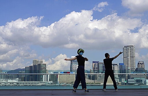 People exercise at the waterfront in Hong Kong, Feb. 26, 2020. (AP Photo/Vincent Yu)