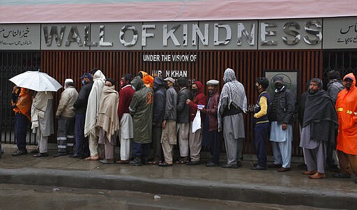 Daily wage workers left jobless due to travel restrictions aimed at containing the coronavirus, wait their turn to receive free food in Rawalpindi, Pakistan, Tuesday, March 24, 2020.  According to the World Health Organization, most people recover from the virus in about two to six weeks, depending on the severity of the illness. (AP Photo/Anjum Naveed)