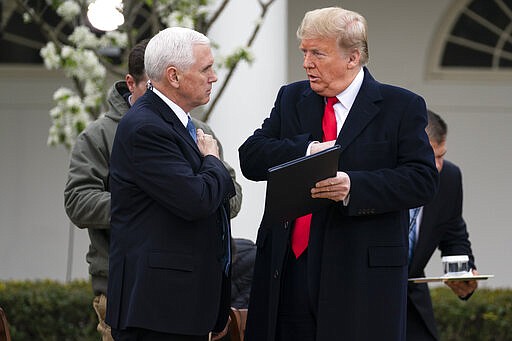 President Donald Trump talks with Vice President Mike Pence before a Fox News virtual town hall with members of the coronavirus task force, in the Rose Garden at the White House, Tuesday, March 24, 2020, in Washington. (AP Photo/Evan Vucci)