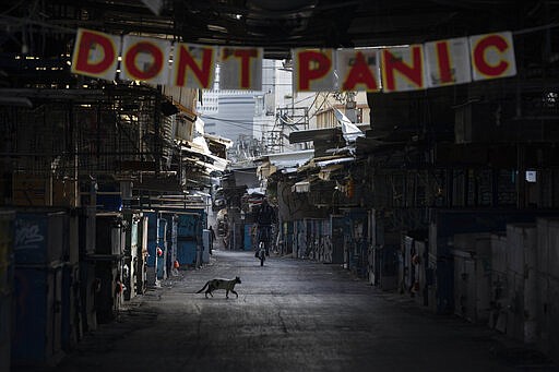 A &quot;don't panic&quot; sign hang on the entrance of a closed food market that was shut down in order to reduce the spread of the coronavirus, in Tel Aviv, Israel, Monday, March 23, 2020. In Israel daily life has largely shut down with coronavirus cases multiplying greatly over the past week. (AP Photo/Oded Balilty)