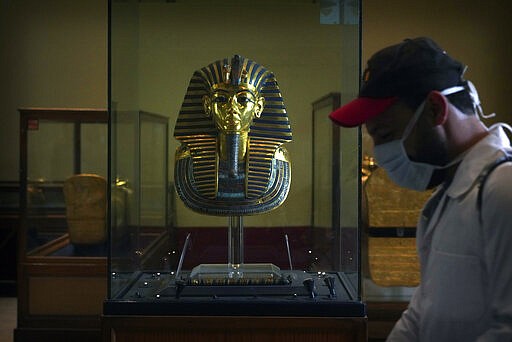 A worker disinfects around King Tut's famous mask in the Egyptian Museum in an effort to help prevent the spread of the coronavirus, in Tahrir Square, Cairo, Egypt, March 23, 2020. (AP Photo/Hamada Elrasam)