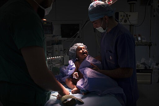 Yazan, 1, cries as he is prepared for heart surgery at the Tajoura National Heart Center in Tripoli, Libya, on Feb. 27, 2020. Libya has only one heart surgeon who can't possibly perform surgeries on 1,200 or so infants born every year with heart defects. But an international team of experts, part of the Novick Cardiac Alliance, regularly flies into Libya to perform surgery on patients like Yazan. (AP Photo/Felipe Dana)